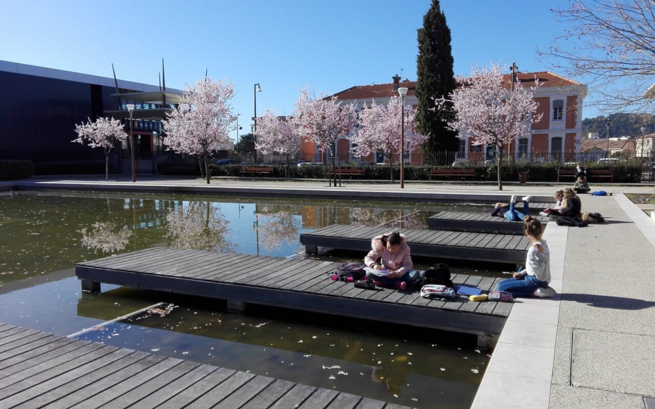 Enfants sur un ponton dessinant le paysage urbain qui les entoure